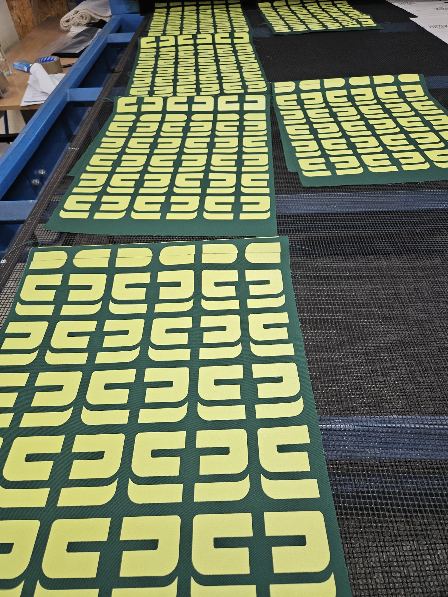 Siebdruck-Produktion: Logoprint auf Stoffbahnen